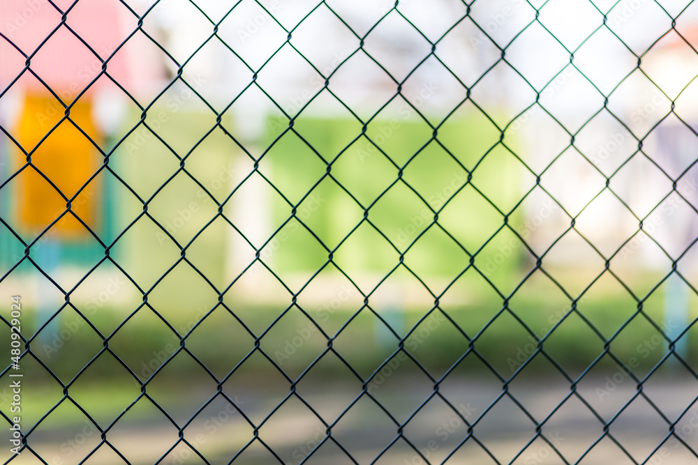 Blurred metal mesh on a blurred green background close-up Blurred metal mesh on a blurred green background close-up