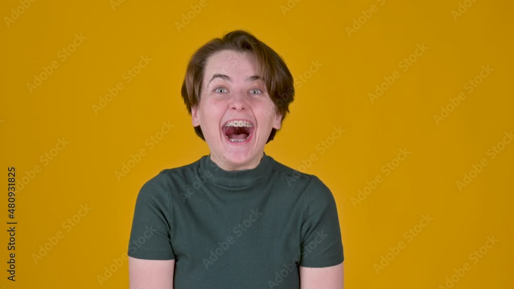 Positive young girl posing isolated on yellow studio background. women looking camera shocked surprised say wow. People emotions lifestyle concept. Positive young girl posing isolated on yellow studio background. women looking camera shocked surprised say wow. People emotions lifestyle concept.