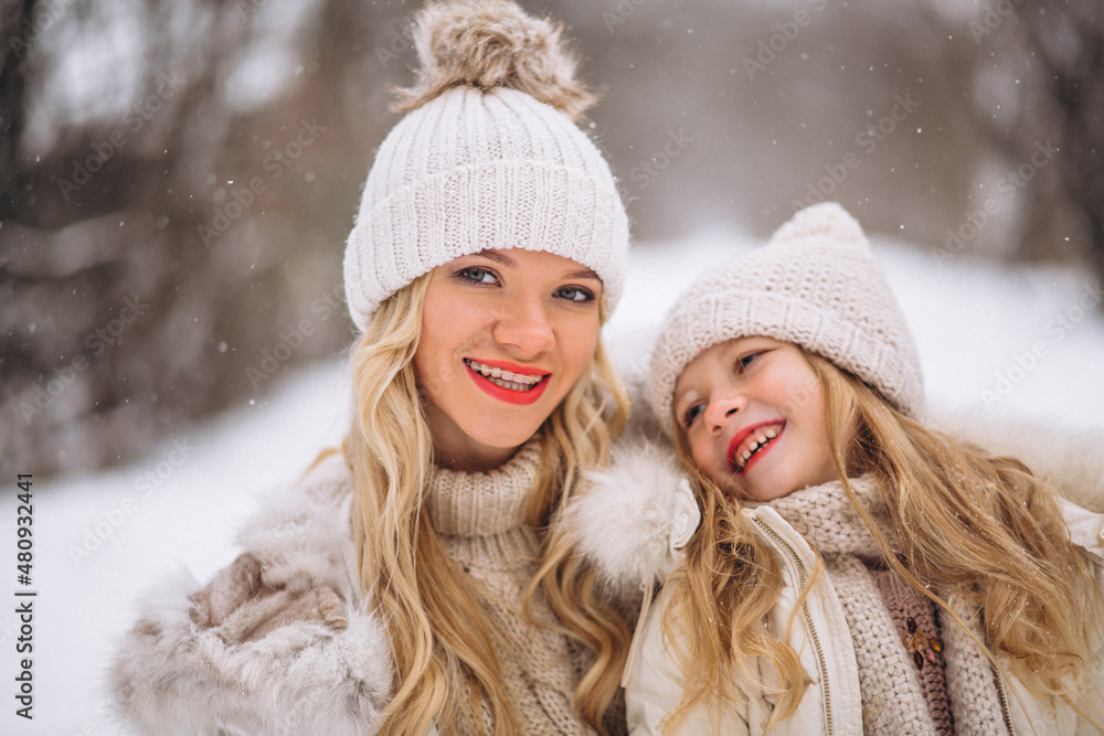 Mother with daughter walking together in a winter park Mother with daughter walking together in a winter park