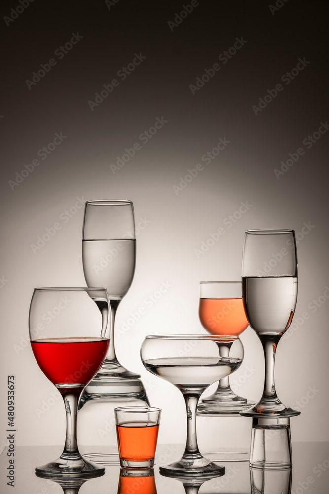 Glassware of different sizes against monochrome background Glassware of different sizes against monochrome background