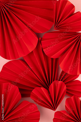 Valentines day background - red paper ribbed hearts different size as pattern  texture  top view  vertical.