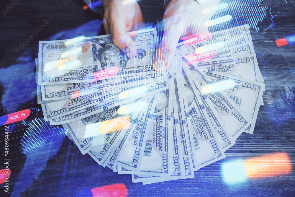 Multi exposure of technology drawing hologram and us dollars bills and man hands. Data concept Multi exposure of technology drawing hologram and us dollars bills and man hands. Data concept