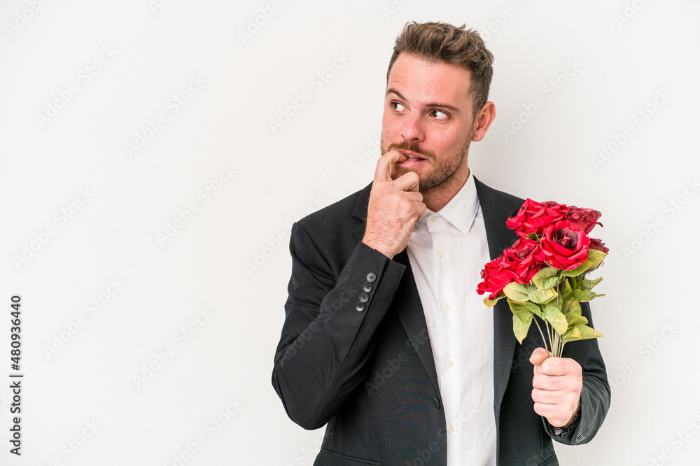 Young caucasian man holding bouquet of flowers isolated on white background relaxed thinking about something looking at a copy space. Young caucasian man holding bouquet of flowers isolated on white background relaxed thinking about something looking at a copy space.