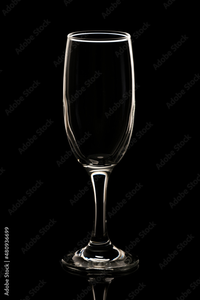 Isolated and illuminated empty champagne glass against black background