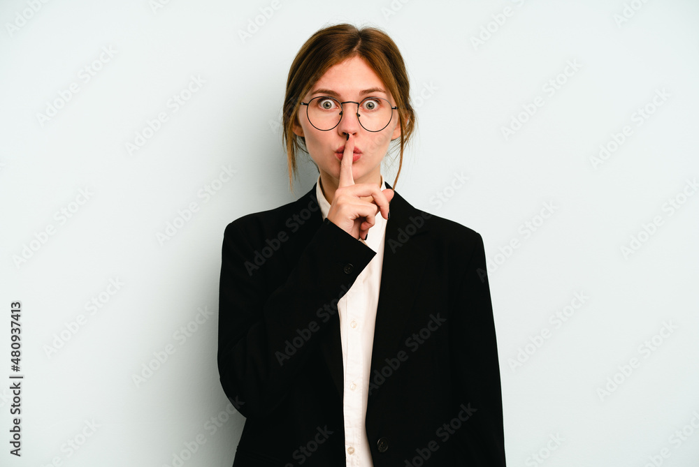 Young business English woman isolated on blue background keeping a secret or asking for silence. Young business English woman isolated on blue background keeping a secret or asking for silence.