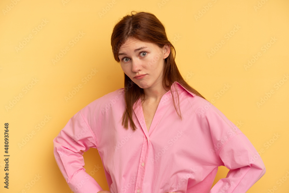 Fototapeta premium Young English woman isolated on yellow background confused, feels doubtful and unsure.