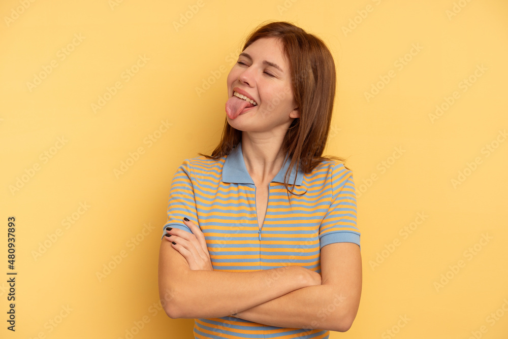 Obraz premium Young English woman isolated on yellow background funny and friendly sticking out tongue.
