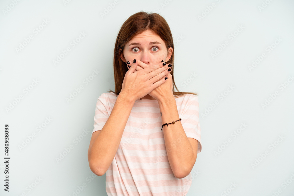 Young English woman isolated on blue background covering mouth with hands looking worried. Young English woman isolated on blue background covering mouth with hands looking worried.