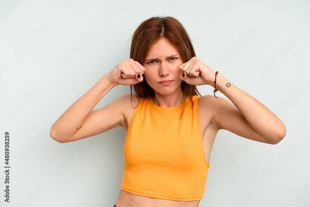 Young English woman isolated on blue background throwing a punch, anger, fighting due to an argument, boxing. Young English woman isolated on blue background throwing a punch, anger, fighting due to an argument, boxing.