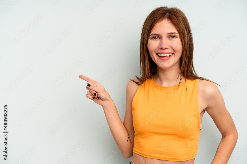 Young English woman isolated on blue background smiling cheerfully pointing with forefinger away. Young English woman isolated on blue background smiling cheerfully pointing with forefinger away.