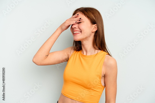 Young English woman isolated on blue background covers eyes with hands, smiles broadly waiting for a surprise. © Asier