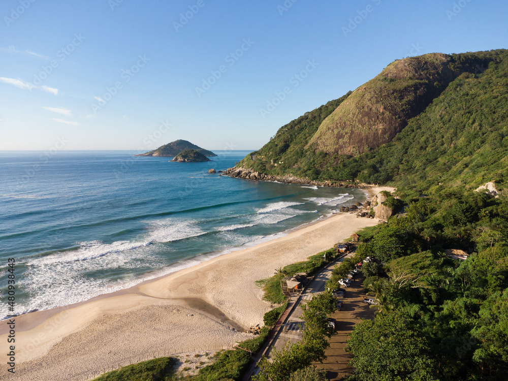 Aerial view of Prainha Beach, a paradise in the west side of Rio de Janeiro, Brazil. Big hills around. Sunny day at dawn. Greenish sea. Drone Photo