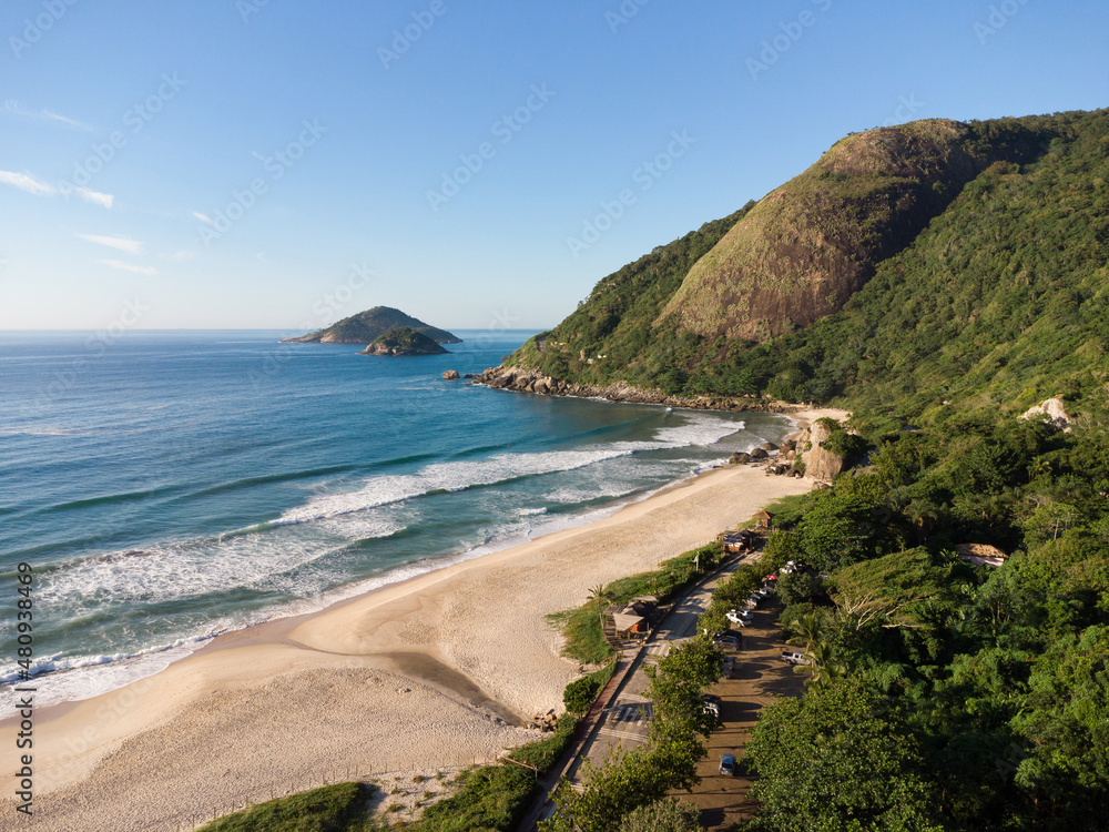 Aerial view of Prainha Beach, a paradise in the west side of Rio de Janeiro, Brazil. Big hills around. Sunny day at dawn. Greenish sea. Drone Photo