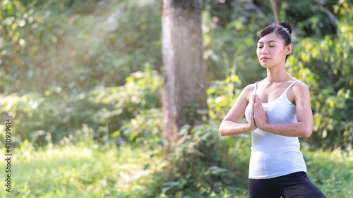 asian woman playing yoga in waterfall outdoor nature background.