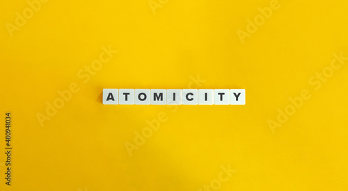 Atomicity Word, Banner and Concept. Letters tiles on bright orange background.