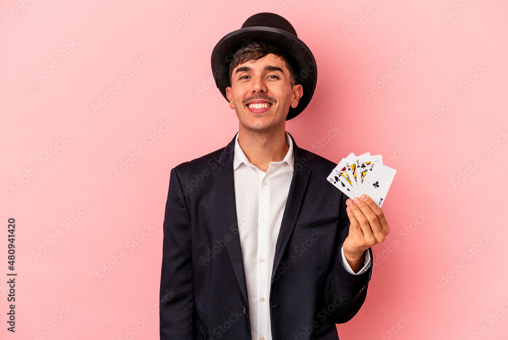 Young caucasian wizard man holding a magic cards isolated on white background happy, smiling and cheerful. Young caucasian wizard man holding a magic cards isolated on white background happy, smiling and cheerful.