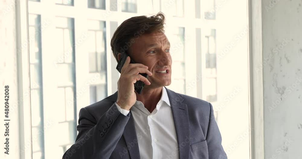 Head shot confident businessman in suit stands in modern skyscraper office talks on smartphone smile look aside. Portrait of successful corporate staff member having phonecall, tech, lifestyle concept Head shot confident businessman in suit stands in modern skyscraper office talks on smartphone smile look aside. Portrait of successful corporate staff member having phonecall, tech, lifestyle concept