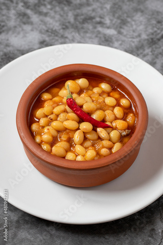 Hot turkish bean stew on dark background. Ispir beans cooked in a casserole - Kuru Fasulye