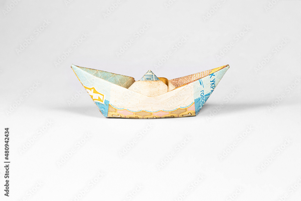 Fototapeta premium boat made from a paper bill of the Ukrainian hryvnia