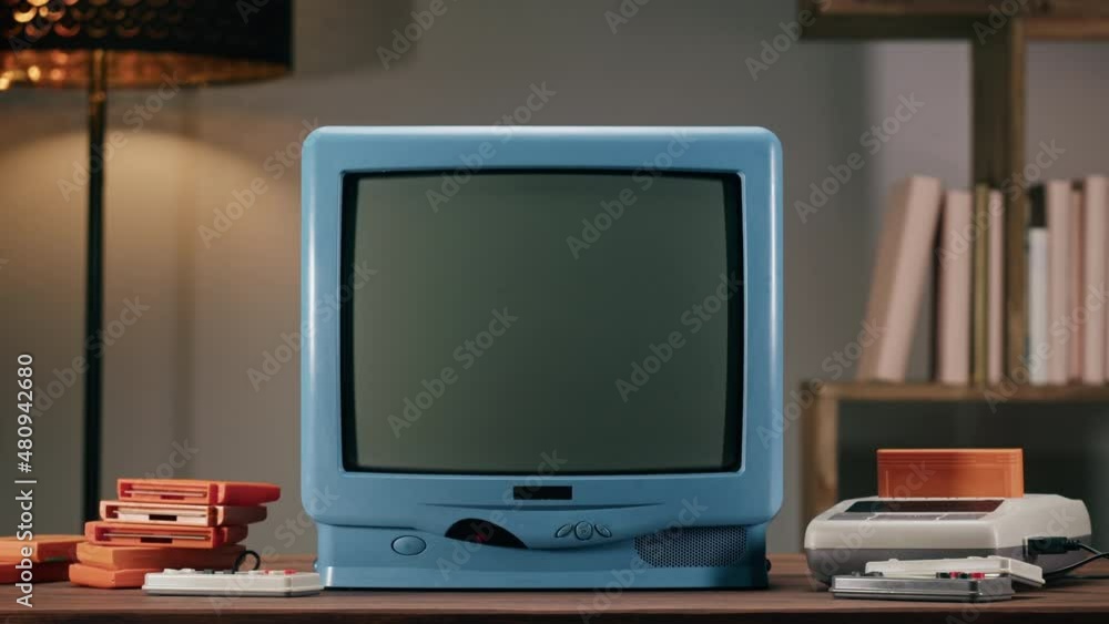 Old television with grey screen on home background. Close-up of vintage tv and cartridges for retro playstation. Antique video game, nostalgia. Old television with grey screen on home background. Close-up of vintage tv and cartridges for retro playstation. Antique video game, nostalgia.