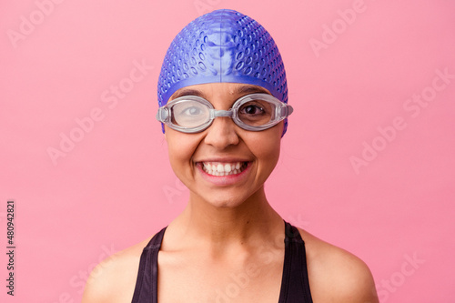 Cheerful swimmer with cap and goggles playfully jokes, capturing joy in the water.