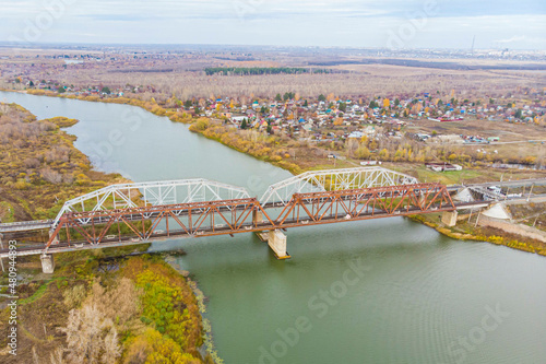 railway bridge photographed from a drone in late autumn across a clear river photo