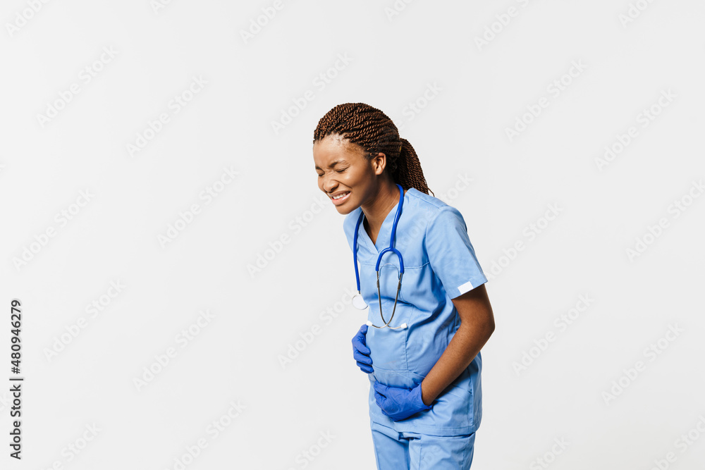 Black pregnant doctor wearing uniform feel pain while holding her belly Black pregnant doctor wearing uniform feel pain while holding her belly
