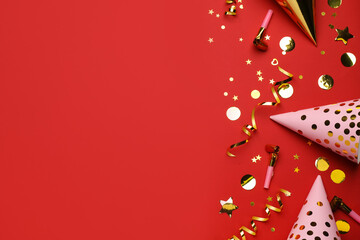 Flat lay composition with party items on red background, space for text
