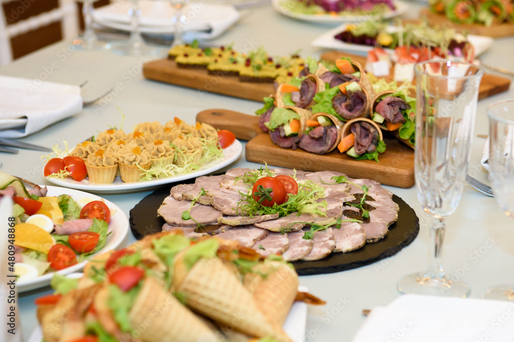 Snacks and dishes on the festive table. Reception of a large number of people in the restaurant. Snacks and dishes on the festive table. Reception of a large number of people in the restaurant.