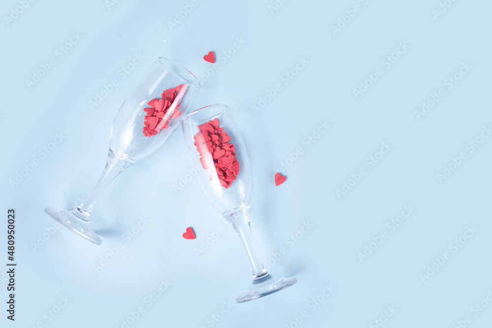 Two champagne glasses with red heart shaped candy. Valentine's Day concept. Two champagne glasses with red heart shaped candy. Valentine's Day concept.