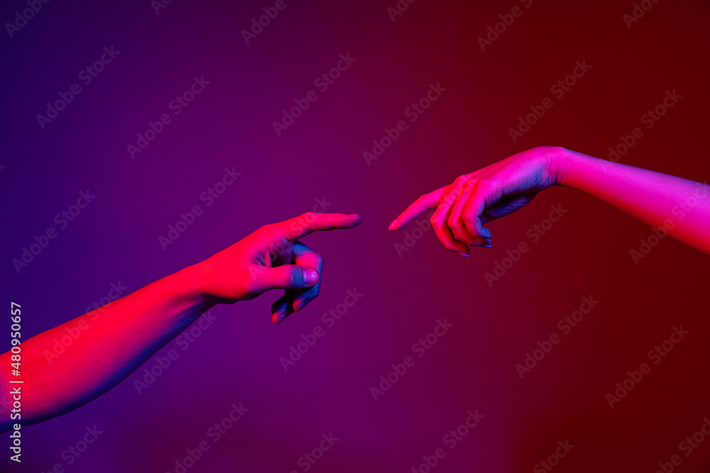 Two Human Hands Trying To Touch Each Other Isolated On Purple Background In Neon Light Concept 