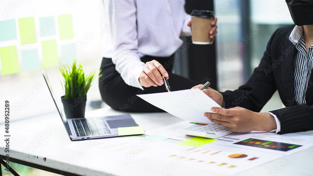Two diverse business women discuss business projects together in the office. Serious talking and brainstorming to share ideas. Two diverse business women discuss business projects together in the office. Serious talking and brainstorming to share ideas.