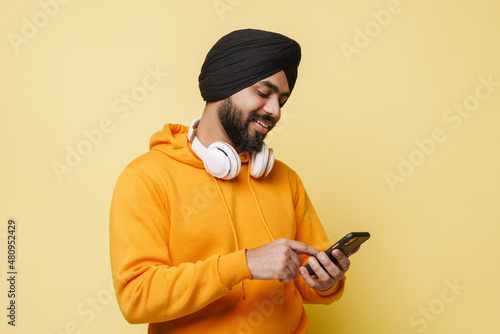 Obraz na plátně Bearded south asian man wearing turban using cellphone