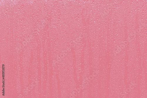 Pacific Pink Rain Droplets Running Down a Window Background. Abstract pastel pink background.