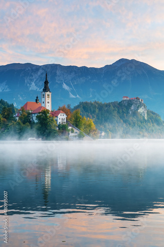 Island of lake Bled in the morning with castle and mountains in background