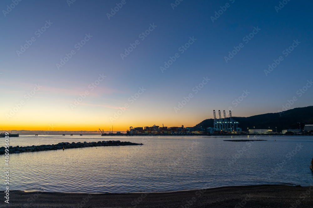 view of the industrial port and harbor of Vado Ligure at sunrise