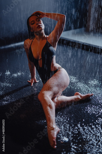 Woman in bikini sitting in the aqua studio under rain drops