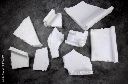 Styrofoam Sheets of different shapes on black background. Pieces of white styrofoam close up. Crumbled styrofoam pieces isolated on dark background