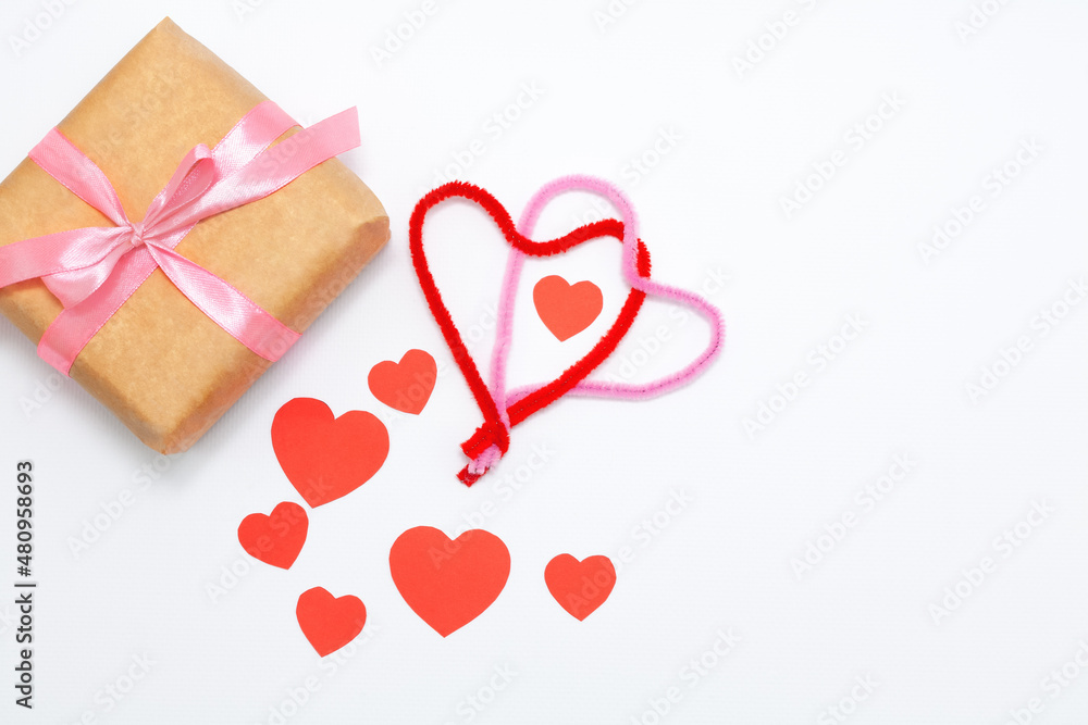 Eco gift boxes with pink ribbon and red felt hearts on white background Eco gift boxes with pink ribbon and red felt hearts on white background