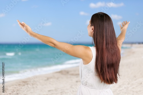 Happy female tourist walks on a sandy beach