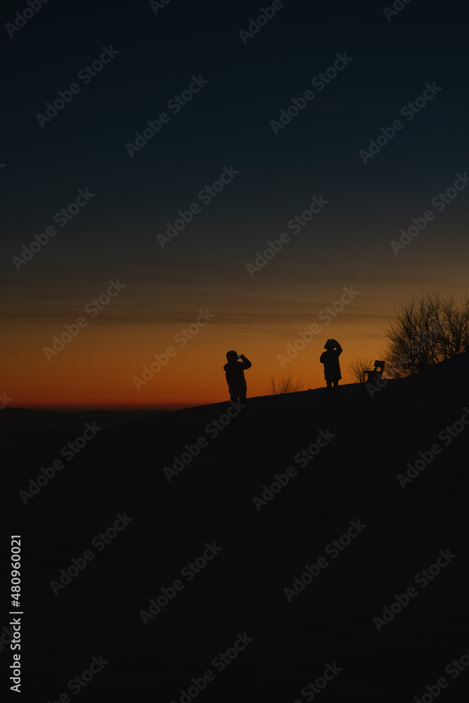 silhouettes of people taking photos