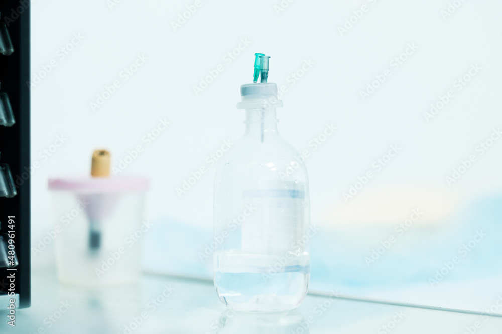 Needles from syringes stick out in a bottle of medicine. Selective focus. Blurry background. Needles from syringes stick out in a bottle of medicine. Selective focus. Blurry background.