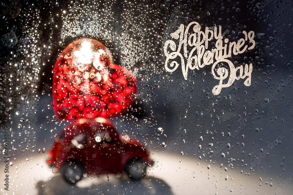 A red retro toy car with a heart on the roof behind a rainy window.Food delivery from cafes and restaurants on Valentine's Day.Blocking, restrictions and sadness in the city because of the coronavirus A red retro toy car with a heart on the roof behind a rainy window.Food delivery from cafes and restaurants on Valentine's Day.Blocking, restrictions and sadness in the city because of the coronavirus