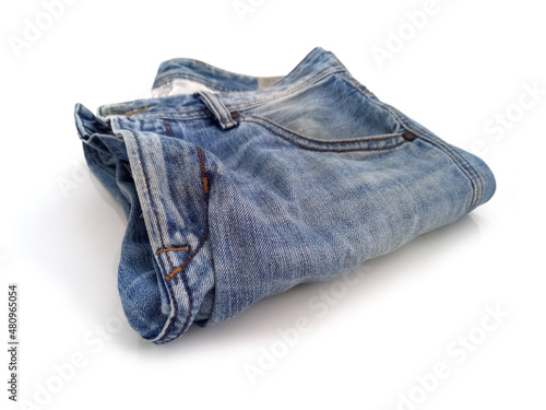 Aerial view of folded blue jean pants. Blue jeans on white background. Close up of used jeans folded. Clothes and fashion concept.