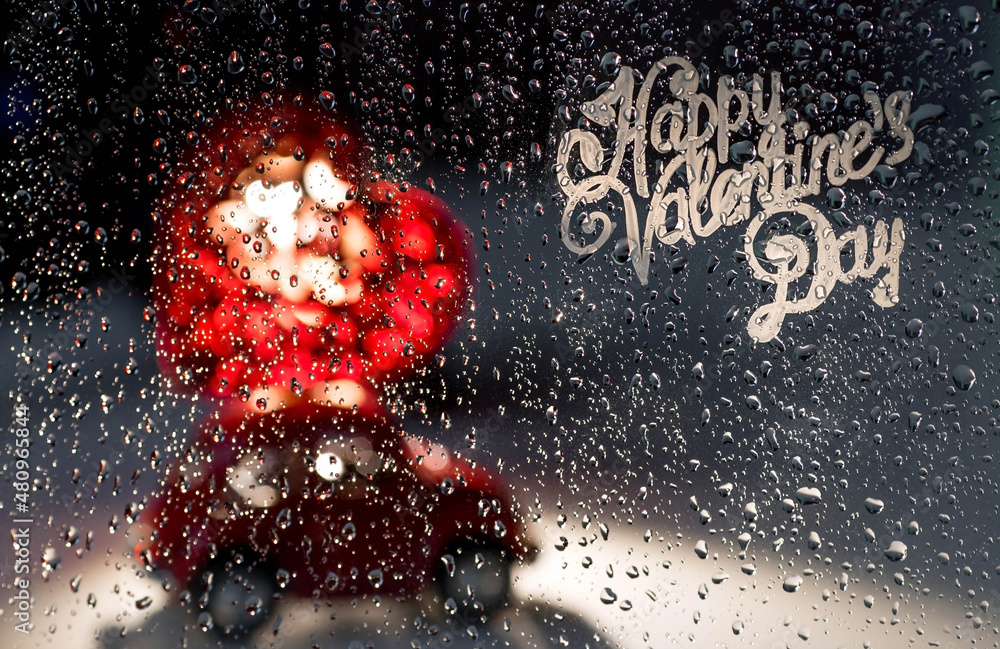 A red retro toy car with a heart on the roof behind a rainy window.Food delivery from cafes and restaurants on Valentine's Day.Blocking, restrictions and sadness in the city because of the coronavirus