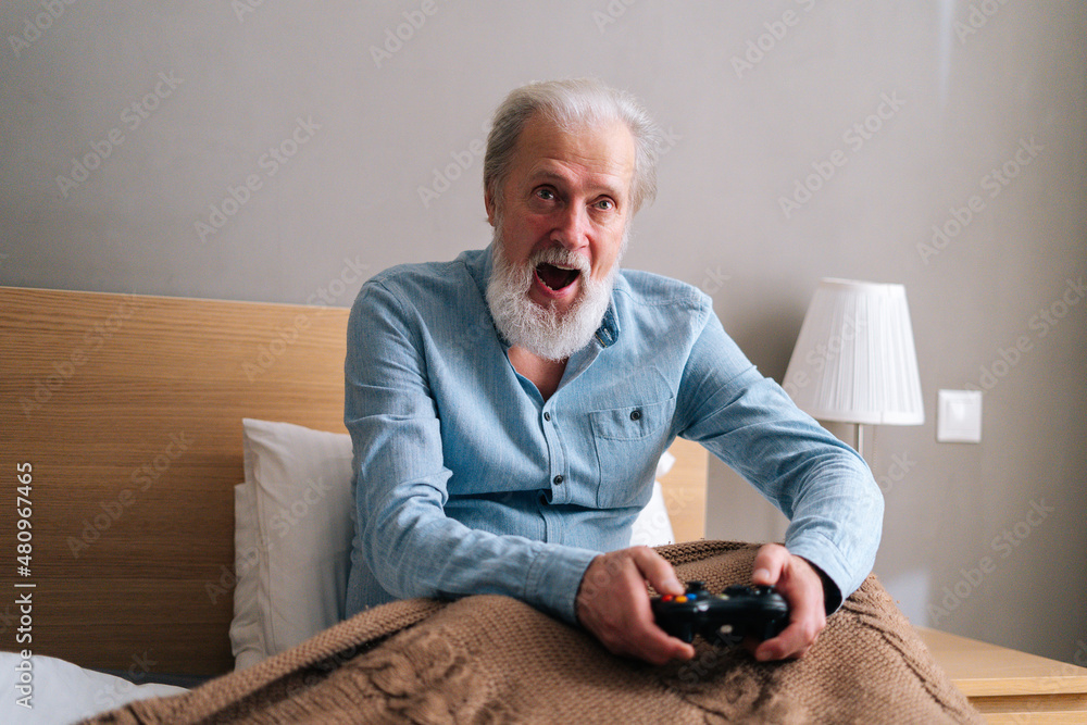 Bearded man playing online video games on his pc and talking with