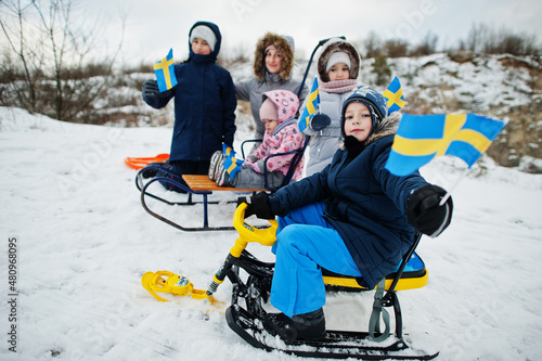 Scandinavian family with Sweden flag in winter swedish landscape.