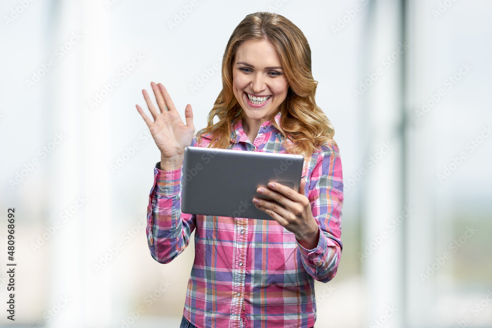 Pretty caucasian woman talking via internet on blur interior background. Pretty caucasian woman talking via internet on blur interior background.
