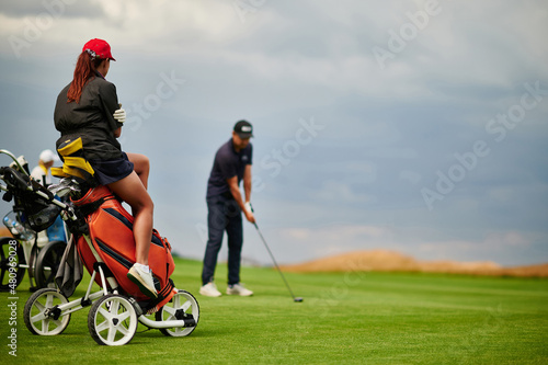 Golfer on a cart in the background of the player