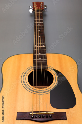  upper soundboard of an acoustic yellow guitar close-up on a gray background